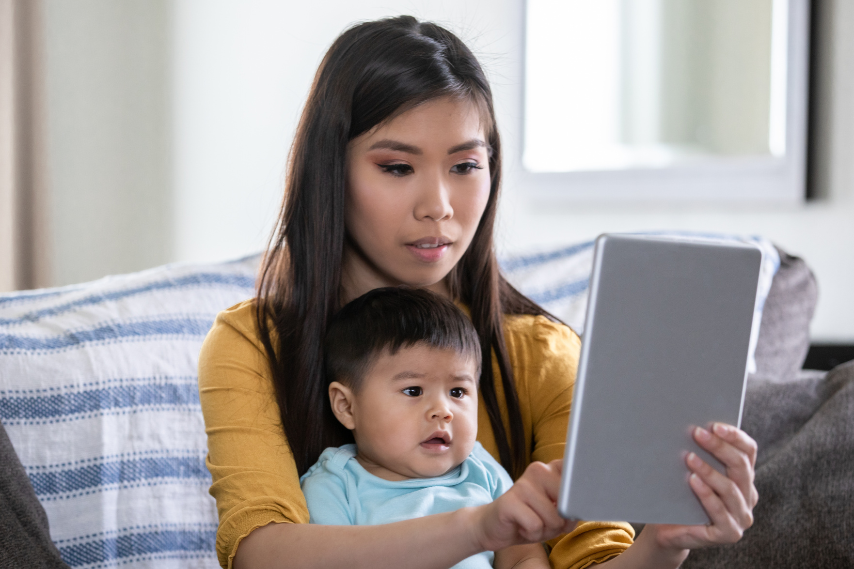 Mother holding baby boy during telehealth call